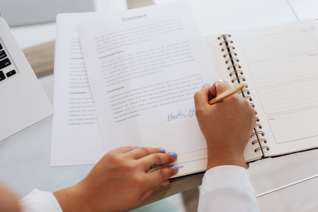 Hands signing a software licence renewal agreement